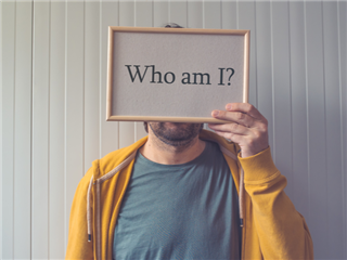 A customer holding a sign over his face that says who am I - customer behavior concept