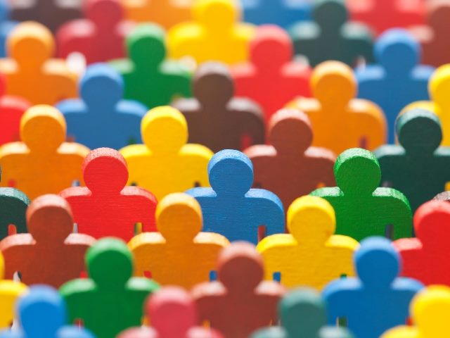 Group of colorful painted wooden figurines in yellow, brown, blue, green and orange.