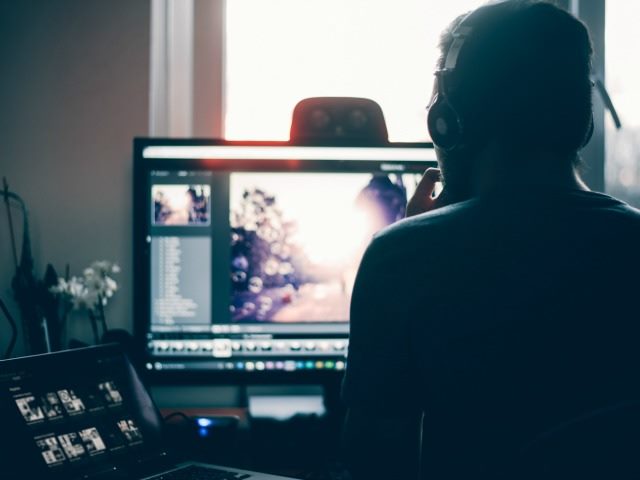 person shown from behind using computer monitors