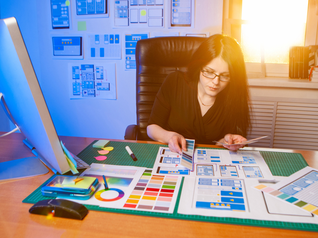 A mobile app designer works on a project in her office on a sunny morning - prototyping realism concept