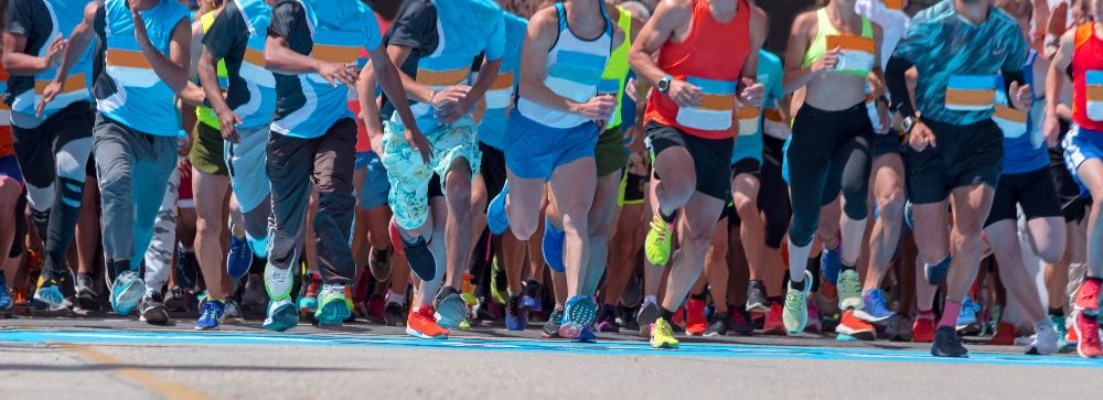 Runners at the starting line of a marathon showing the effort and endurance needed in piece about the importance of customer service training.