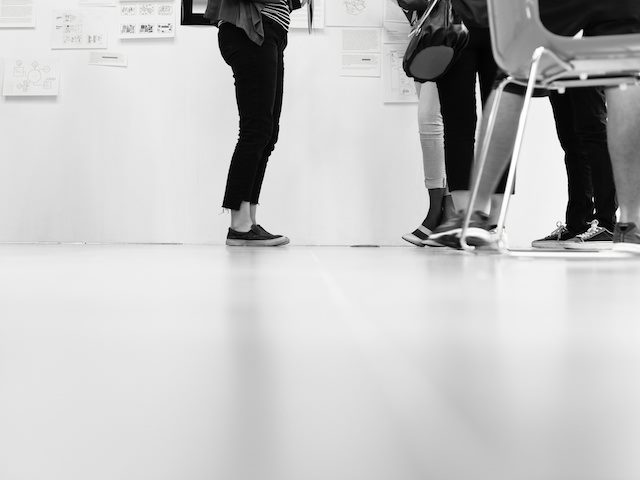 cropped image showing the legs of a group of colleagues with wireframes in the background