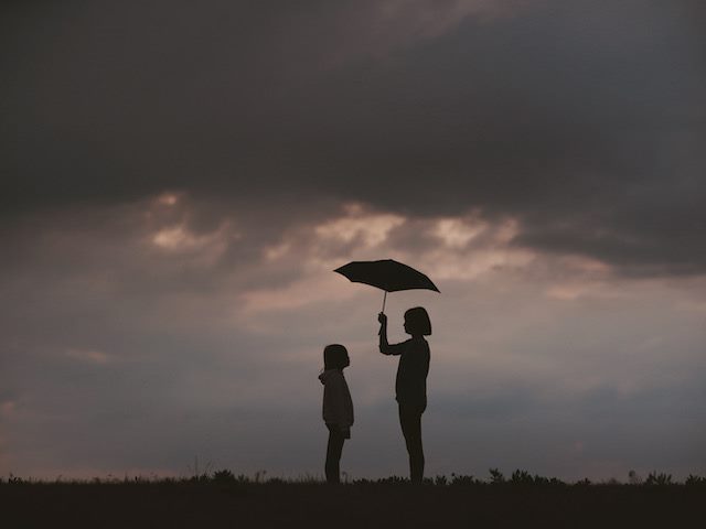 person holding an umbrella over the head of another person