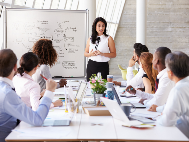 Businesswoman Leading a CX Meeting at a Boardroom Table