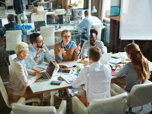 Employees gathered around a conference table.