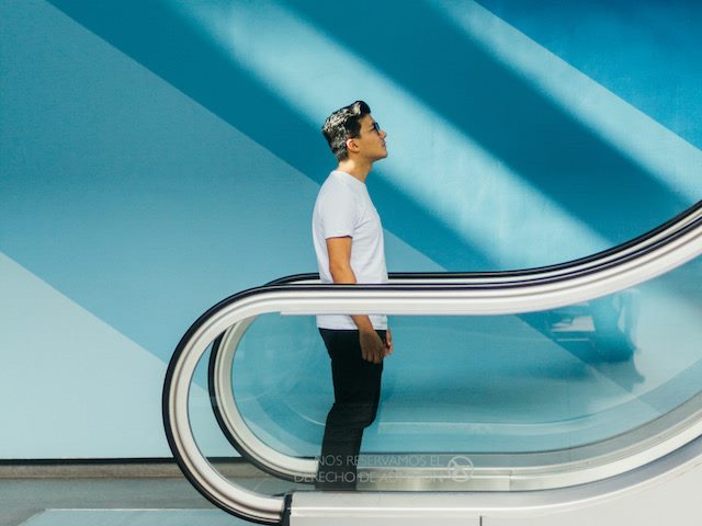 man going up on an escalator