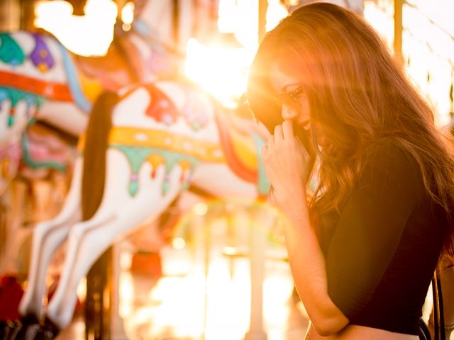 woman by a carousel in sunlight