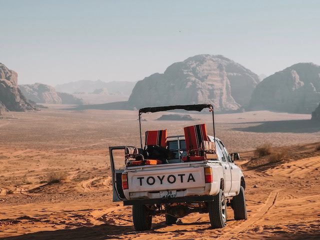 Toyota truck in dessert with mountains in the distance