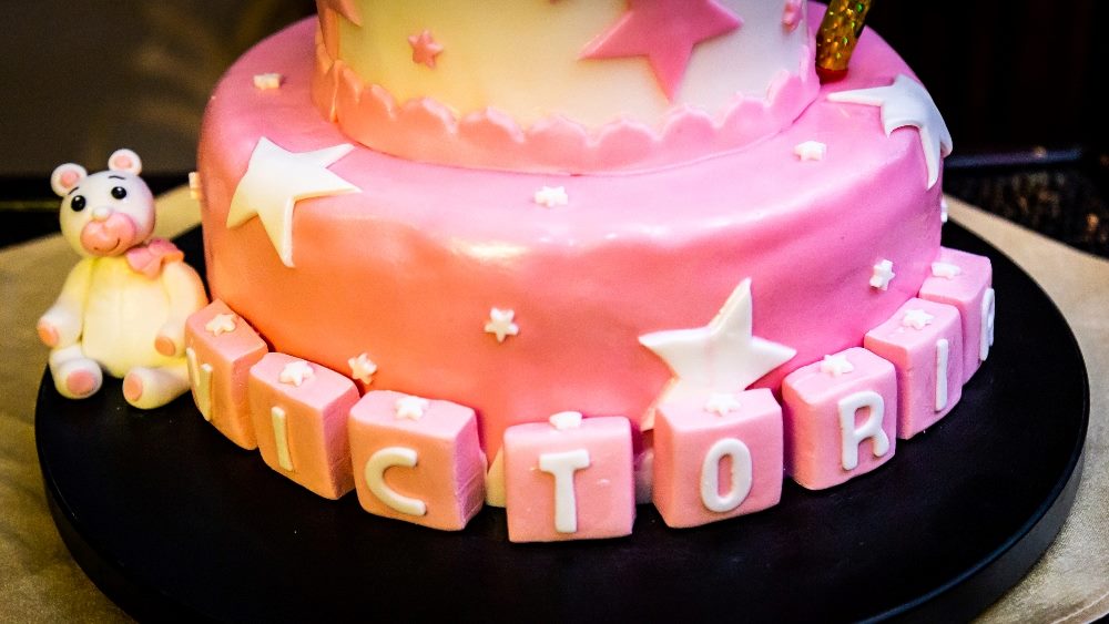 Closeup of a pink birthday cake with stars and the name on a tray on the table in piece about AI-powered personalization in ecommerce.