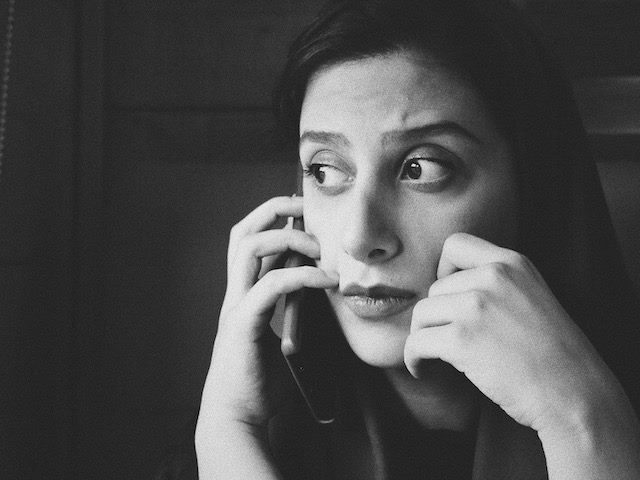pensive  looking woman on a phone  call