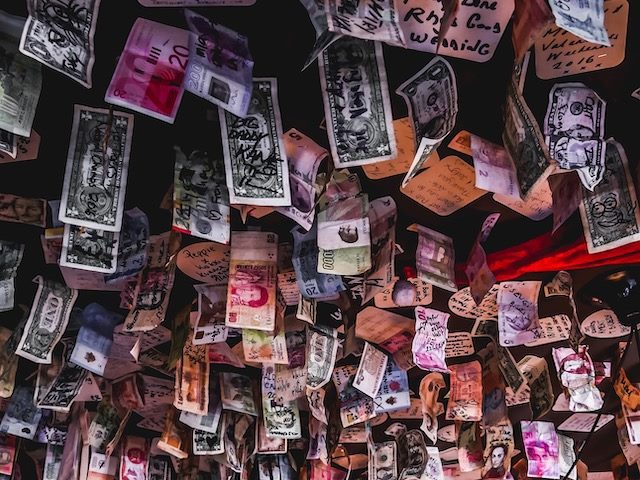 money from around the world hanging from the ceiling of a pub