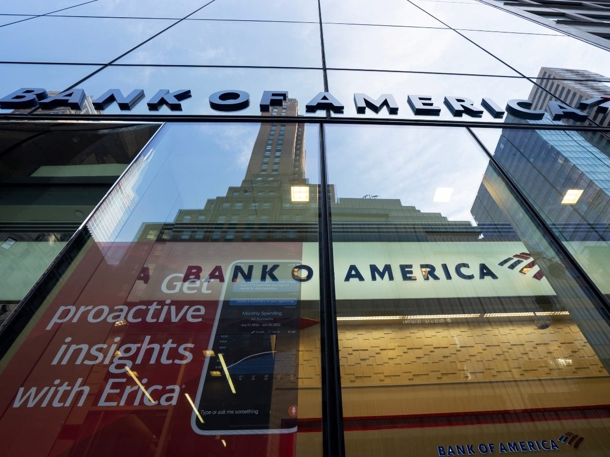 Bank of America branch exterior with glass storefront displaying "Get proactive insights with Erica" advertisement and Erica app interface, with the Bank of America logo visible on the building facade above.