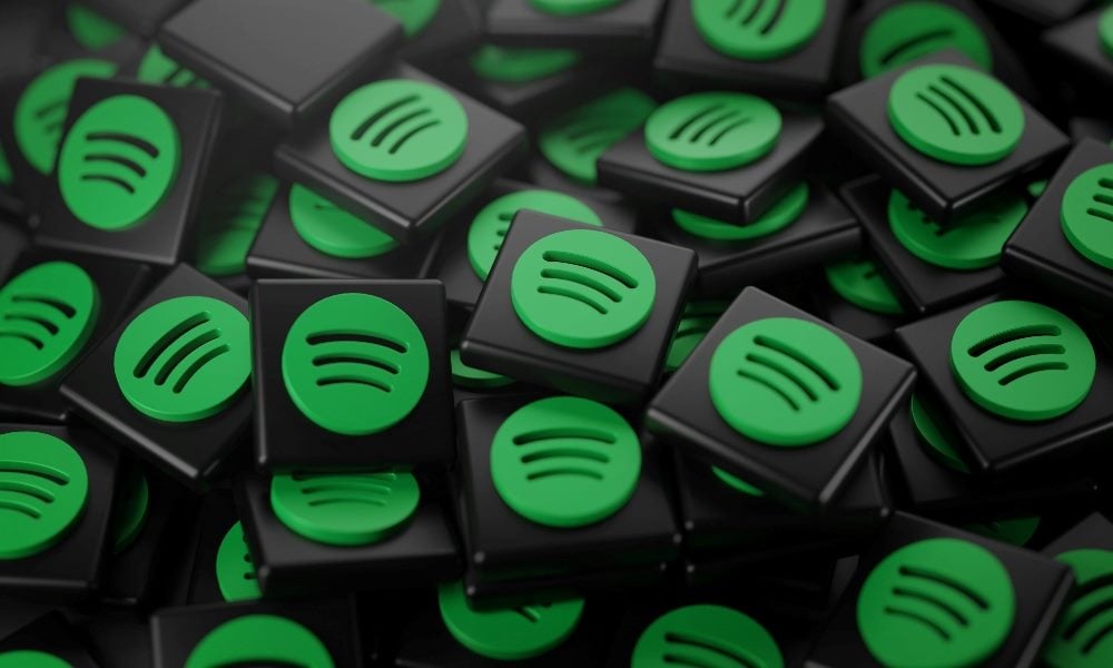 A pile of 3D black tiles featuring the green Spotify logo stacked randomly together.