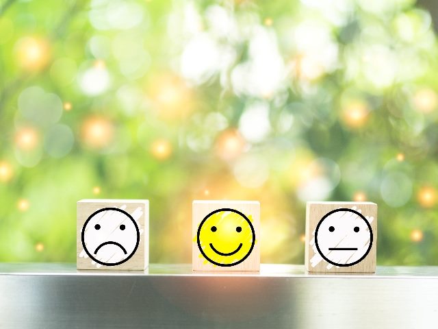 Wooden blocks with the face symbol, showing customer service surveys with an excellent business service rating. 
