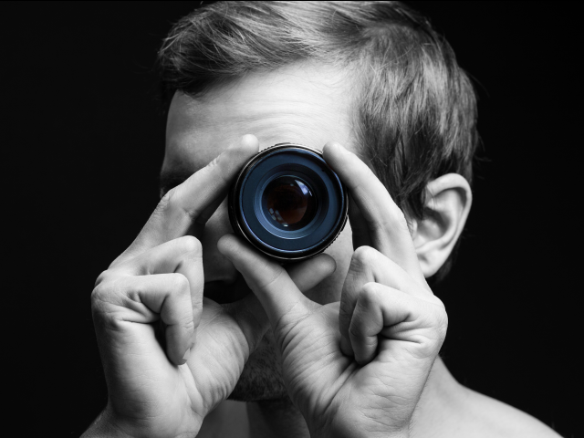 A man looking through a camera lens -  Marketing Microinteraction concept