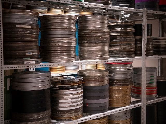  Film reels for old vintage cinema movie projector in video library. 