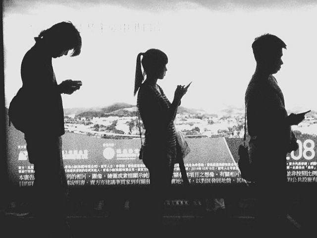 silhoulettes of 3 people with smartphones