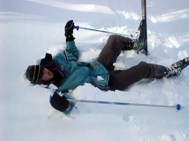 skier lays down in pile of snow