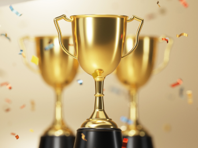 golden trophy award with falling confetti on gold background - CMSWire Impact Award Winners