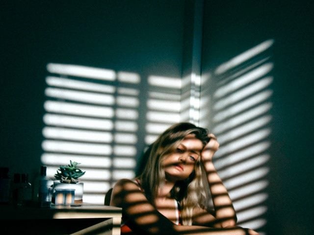 frustrated woman sitting in a corner