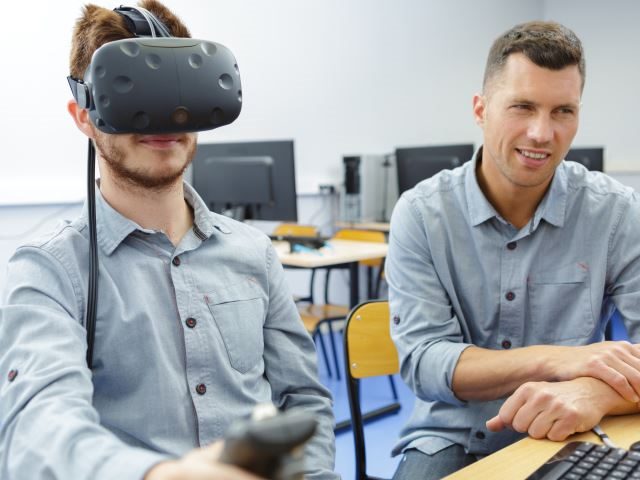  Young man in a technology lab using virtual reality headset - vr training concept