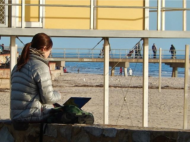 on a laptop on a beach