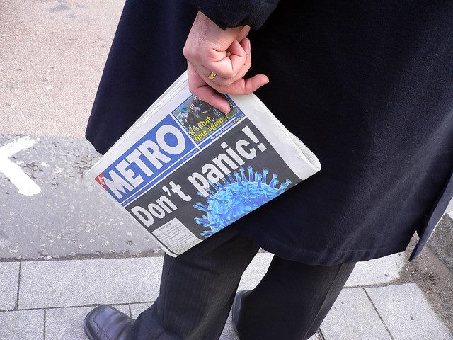 man holding metro paper with headline "don't panic!"