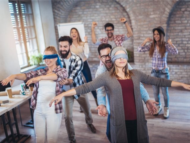 Workers in a modern office preforming trust exercises