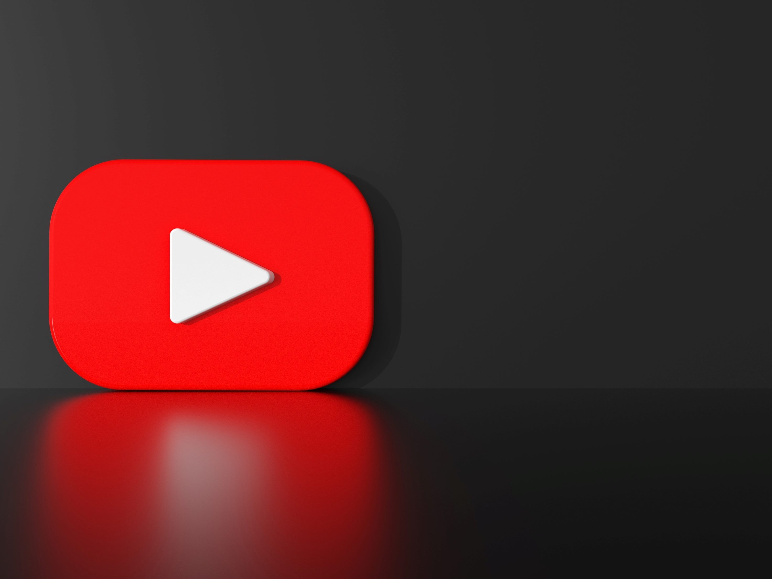 The red and white YouTube logo on a dark background with play arrow in story about YouTube's podcast discovery efforts. 