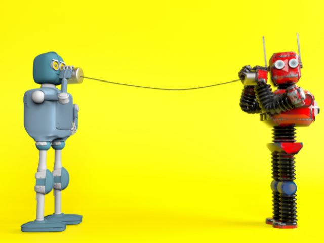 two retro robots holding tin can phones