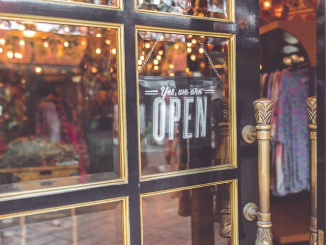 A storefront with an open sign in the window 