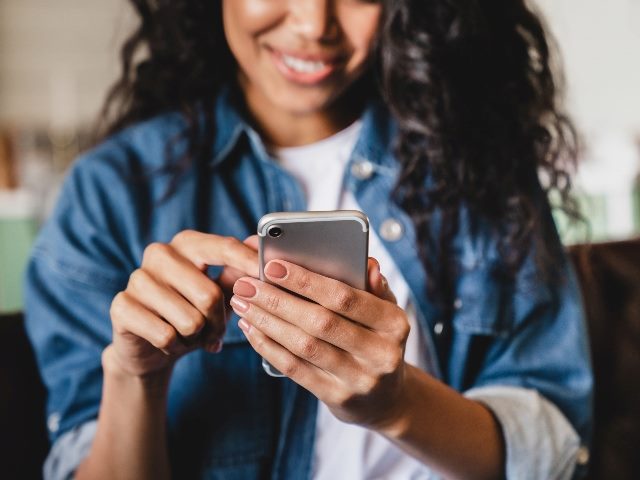 Woman holding phone smiling