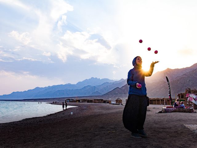 woman juggling on a beach