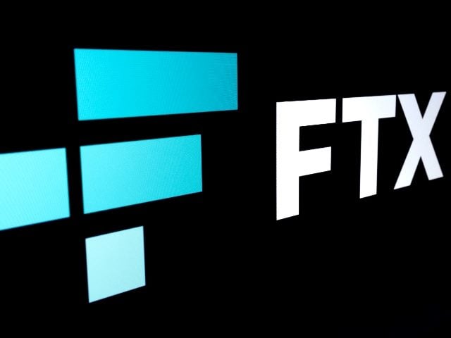 FTX Cryptocurrency Exchange company logo seen on a dark background in piece about Bankman-Fried trail. 