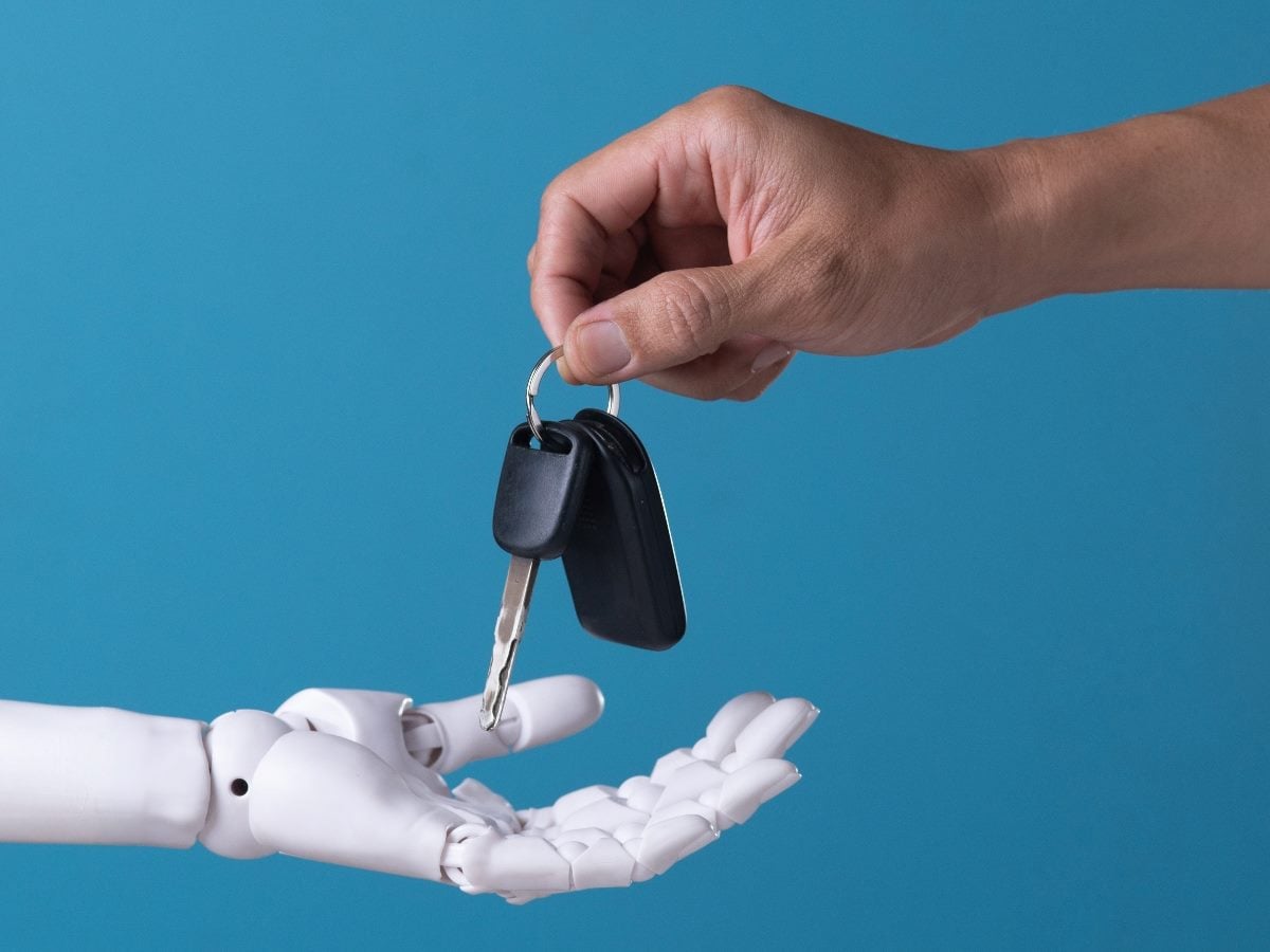 Human handing car keys to robot hand.