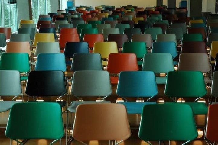 empty chairs of many colors in an auditorium