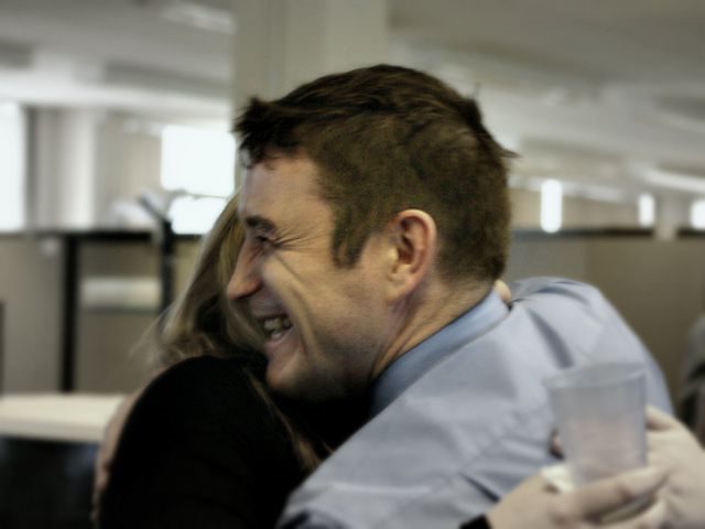 two office workers hugging