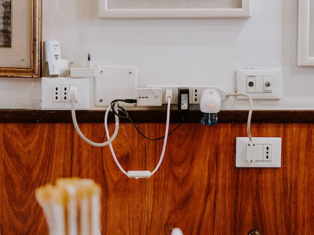 an excess of plugs on a wall
