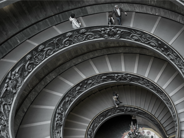 people walking down a spiral staircase