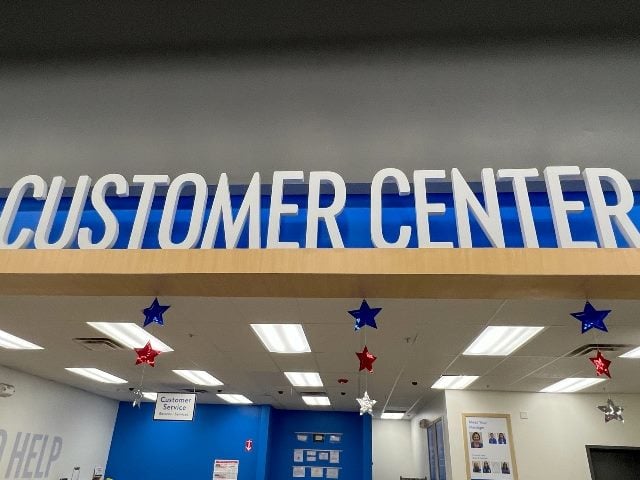 A "Customer Center" sign at the Customer Service counter at a Walmart Store with no people.