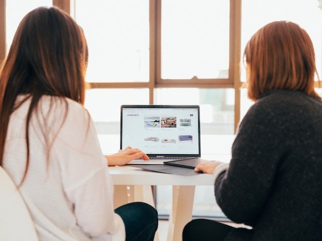 two women searching for couches online