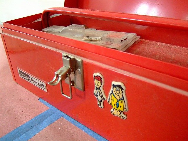 red toolbox with magnets of Fred Flintstone and Barney Rubble on it.