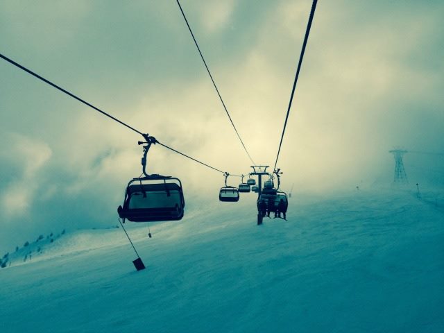 skiers in a ski lift, separated by compartment
