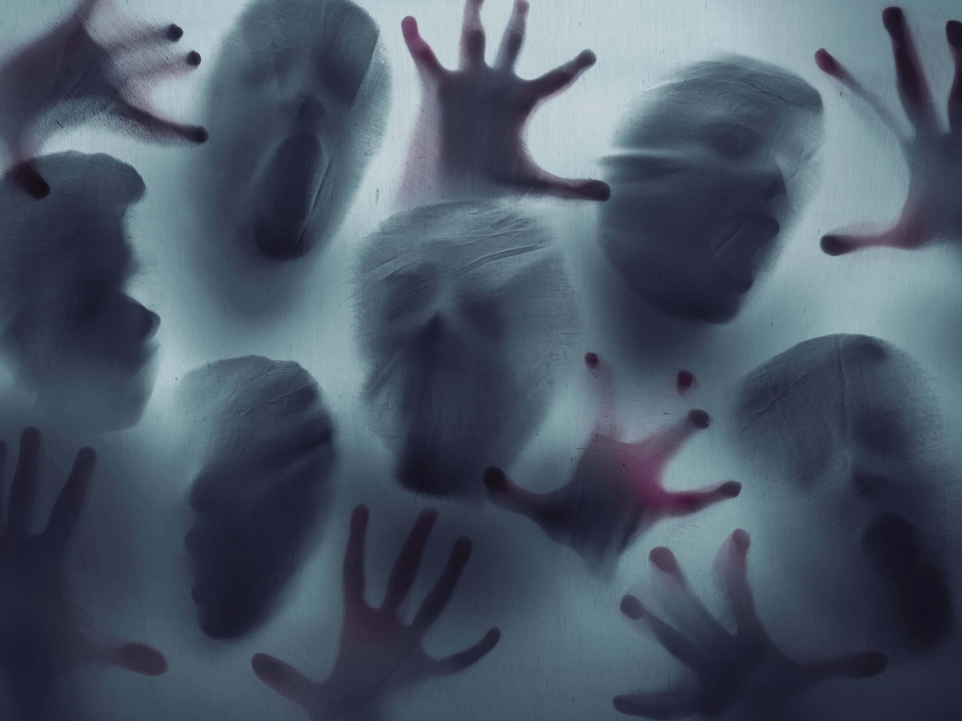 Dangerous and scary looking shadow faces and hands suggesting the dangers of AI technology and shadow AI. 