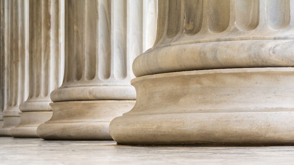 Architectural detail of the bottom of marble made in the Greek Ionic style of columns in piece about customer empowerment.