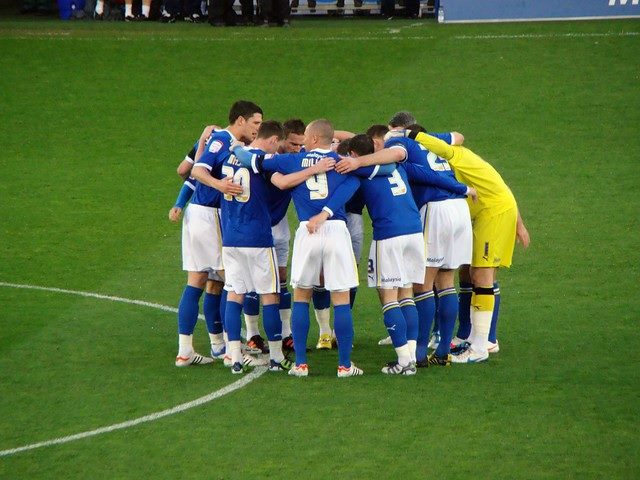 Men's team soccer huddle during a game.