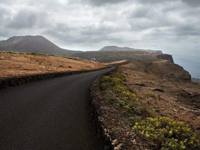 Empty road with no people on Lanzarote, Canary island. Hills ahead 