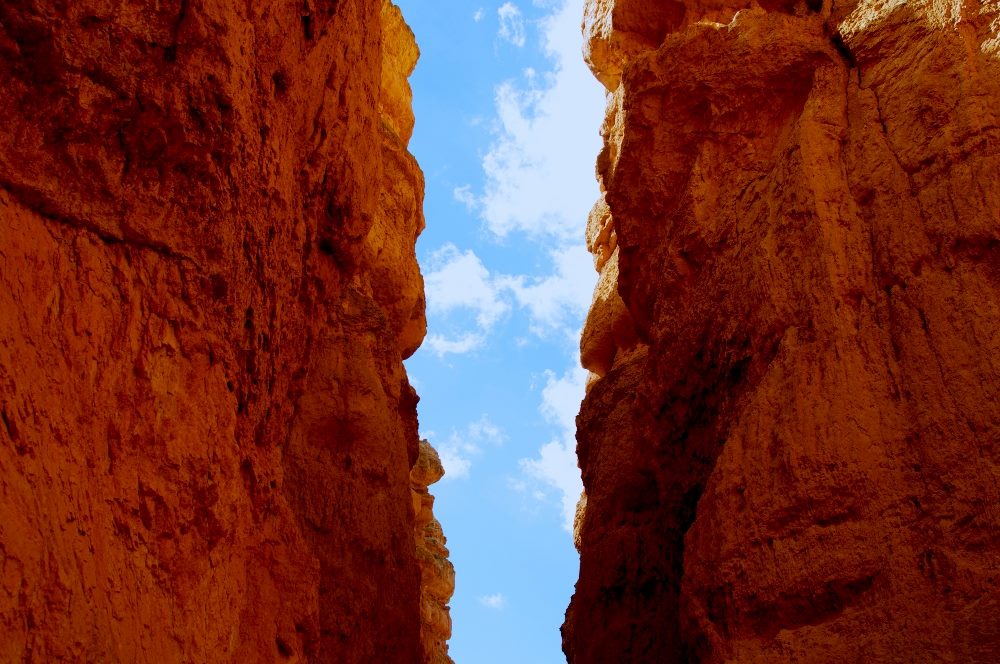 A gap between two red cliff sides with blue skies visible in the background in piece about brick and mortar cx trends.