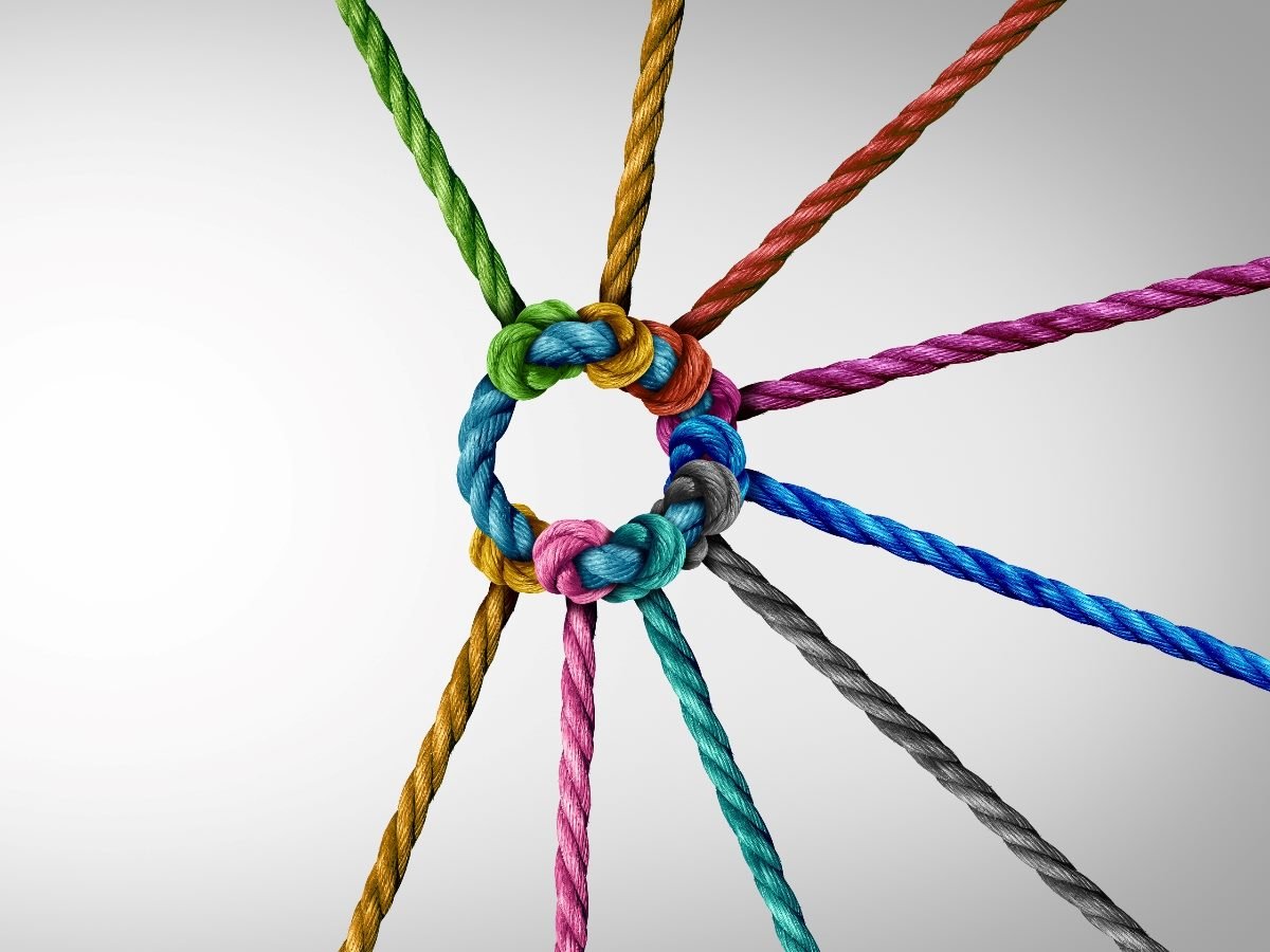 Close-up of colorful ropes tied together in a tight circular knot, symbolizing unity, teamwork, and collaboration.
