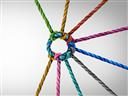 Close-up of colorful ropes tied together in a tight circular knot, symbolizing unity, teamwork, and collaboration.